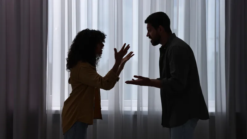 Emotional Couple Arguing Indoors At Night Relationship Problems